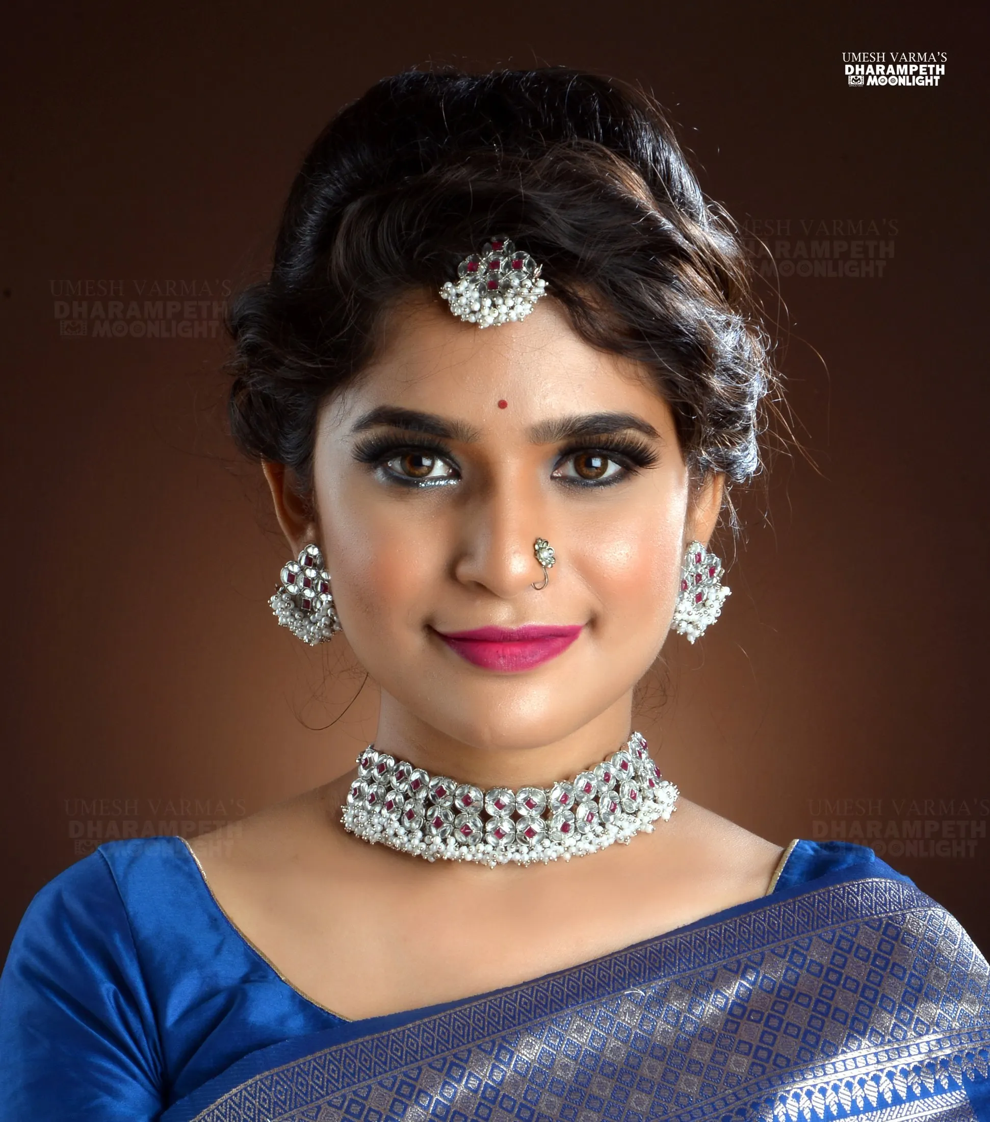 Portrait of a woman in a blue silk saree and traditional jewellery
